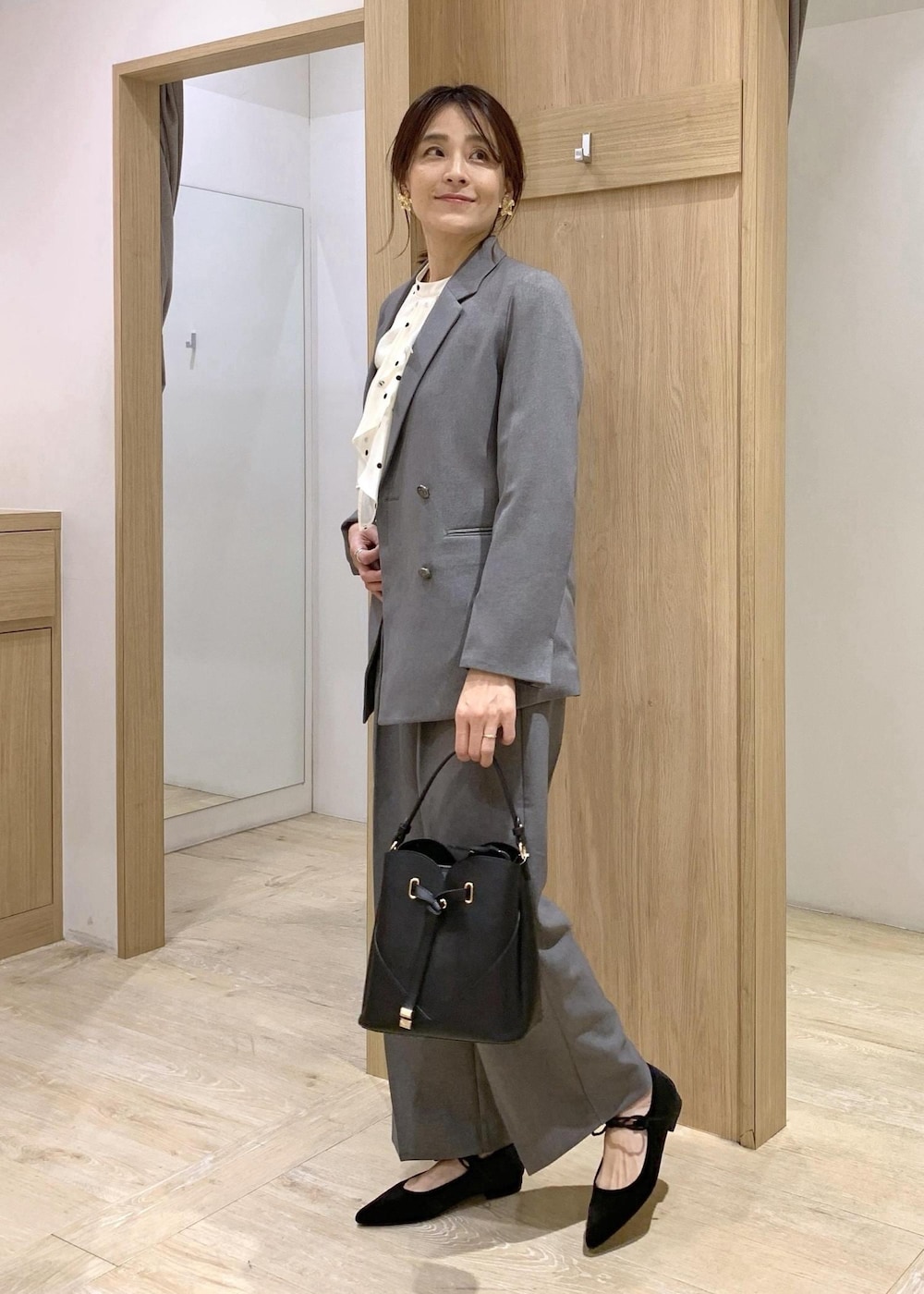 ブラック系のショルダーバッグ、グレー系のスラックス、グレー系のテーラードジャケットを着用したレディースの冬コーディネートの3枚目の写真