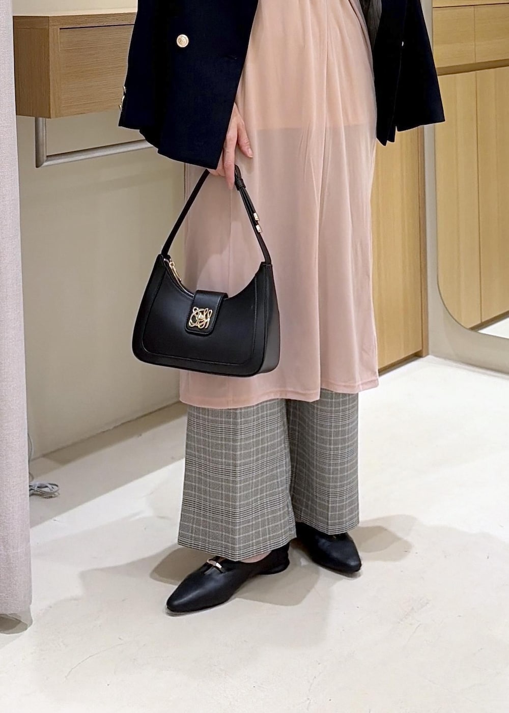 ブラック系のショルダーバッグ、ブラック系のパンプス、ピンク系のスカートを着用したレディースの秋コーディネートの8枚目の写真