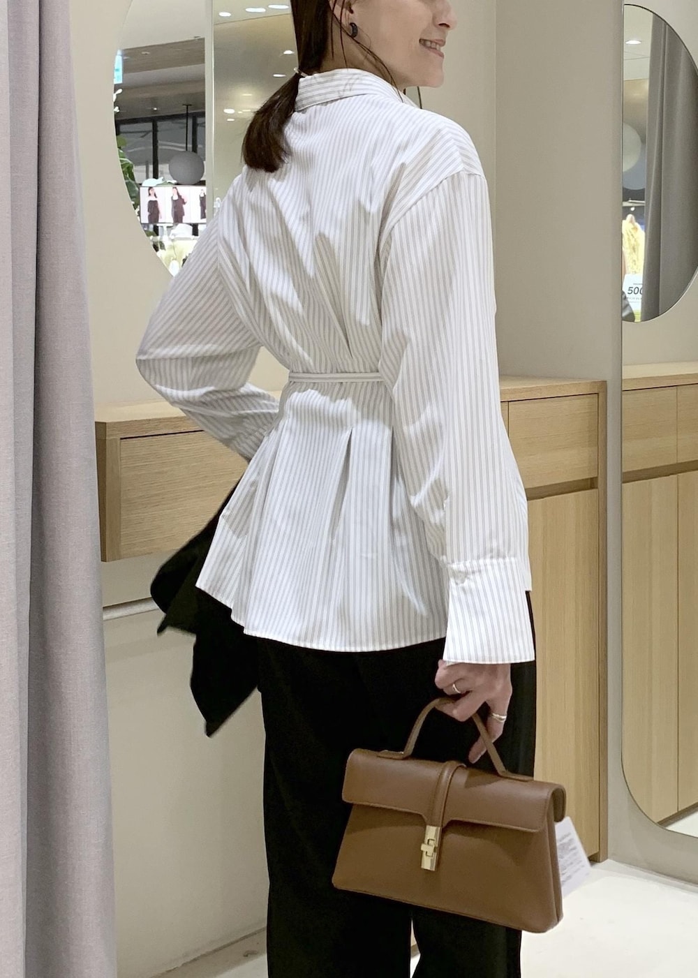 イエロー系のショルダーバッグ、ブラック系のテーラードジャケット、ブラック系のその他パンツを着用したレディースの春コーディネートの9枚目の写真