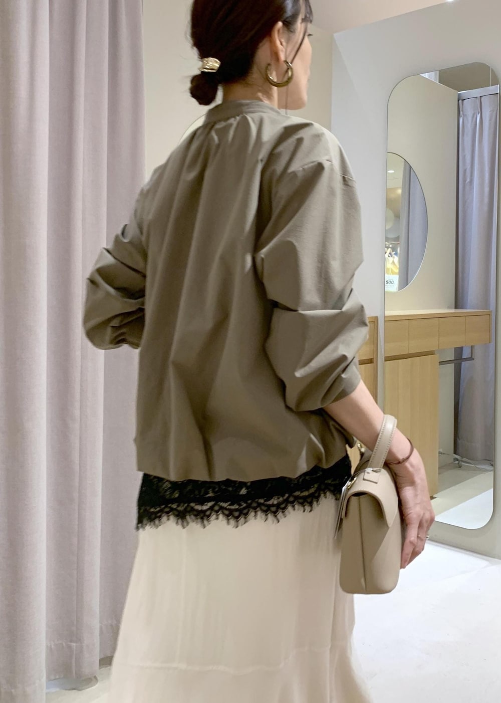 ベージュ系のパンプス、ホワイト系のスカート、ブラック系のキャミソールを着用したレディースの春コーディネートの9枚目の写真