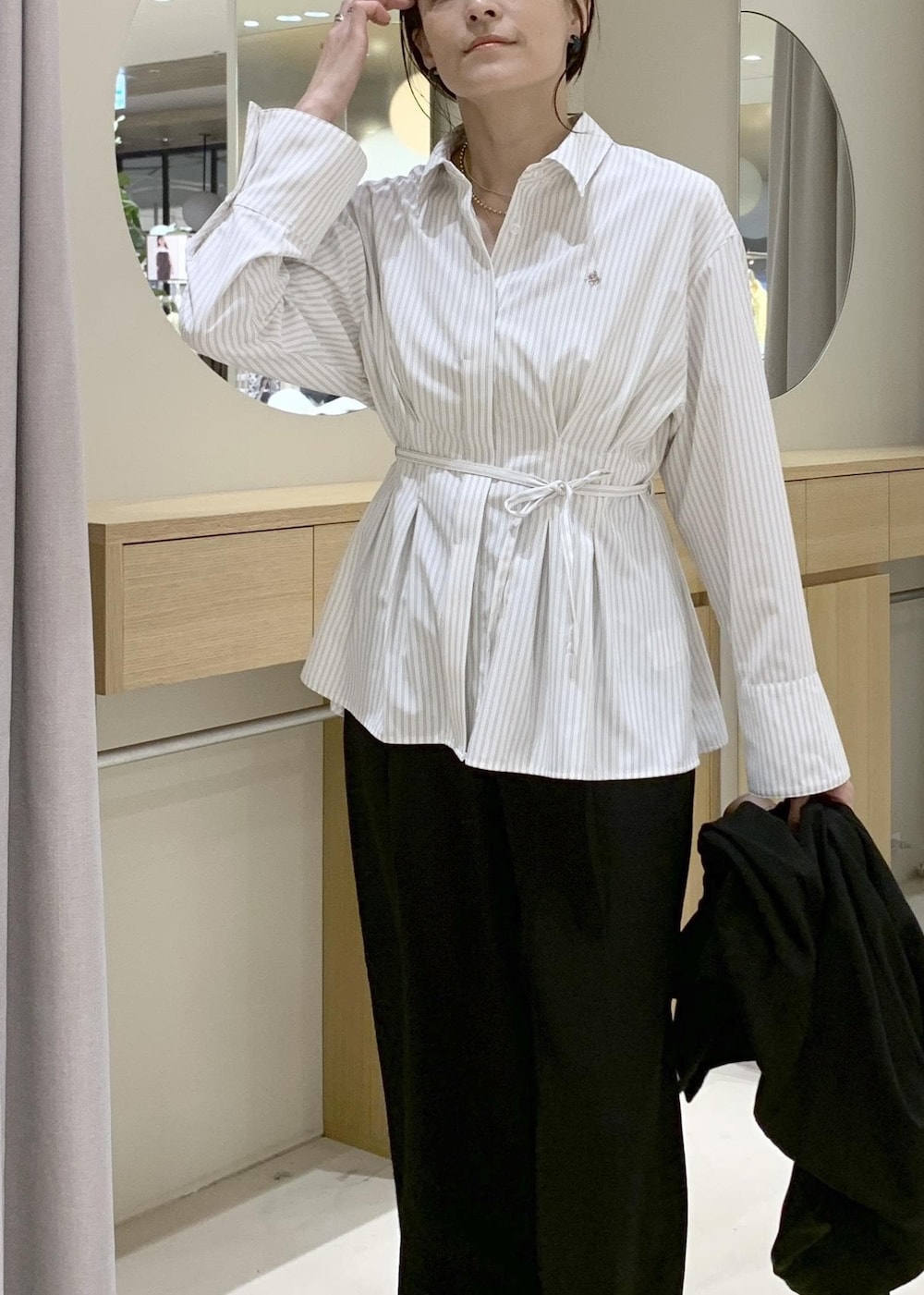 イエロー系のショルダーバッグ、ブラック系のテーラードジャケット、ブラック系のその他パンツを着用したレディースの春コーディネートの7枚目の写真