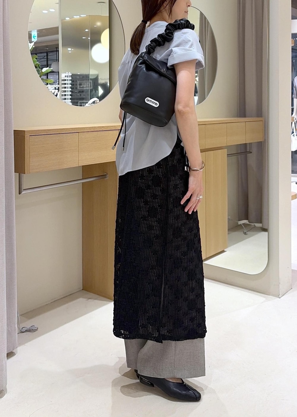グレー系のその他パンツ、ブラック系のパンプス、ブラック系のショルダーバッグを着用したレディースの春コーディネートの3枚目の写真