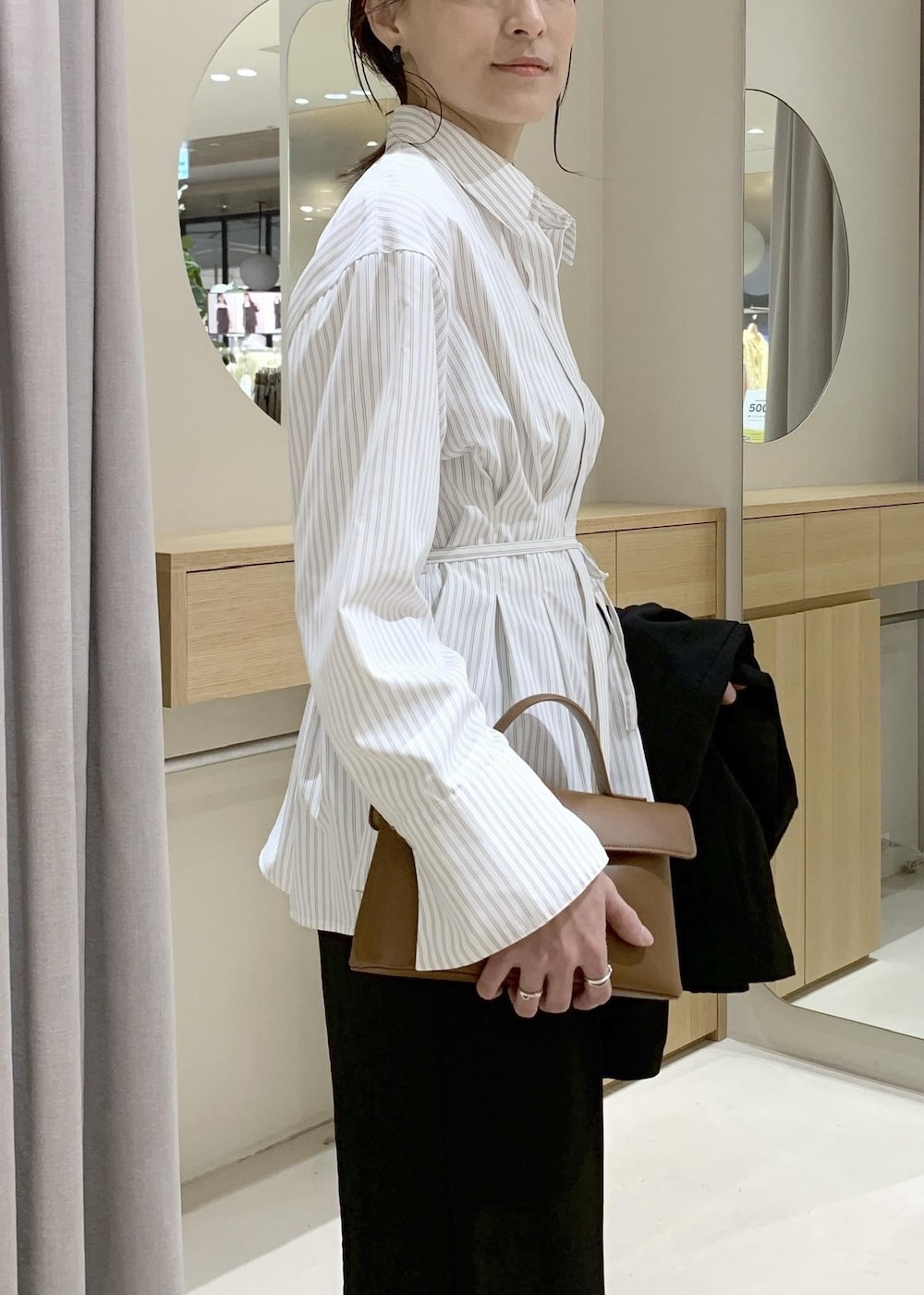 イエロー系のショルダーバッグ、ブラック系のテーラードジャケット、ブラック系のその他パンツを着用したレディースの春コーディネートの8枚目の写真