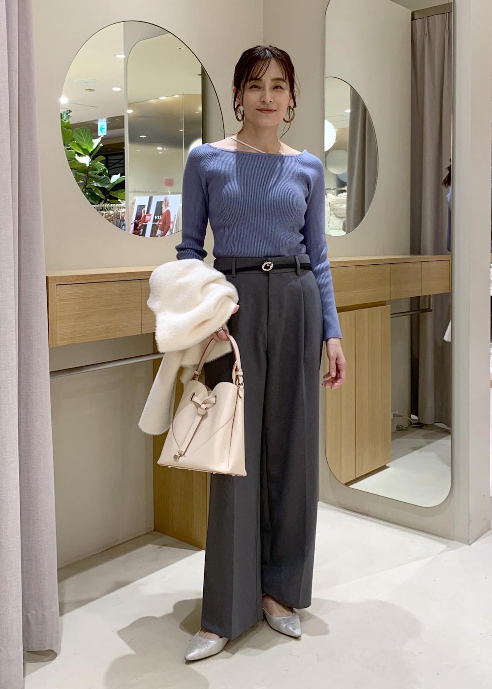 ベージュ系のショルダーバッグ、グレー系のスラックス、ホワイト系のカーディガン/ボレロを着用したレディースの冬コーディネートの7枚目の写真