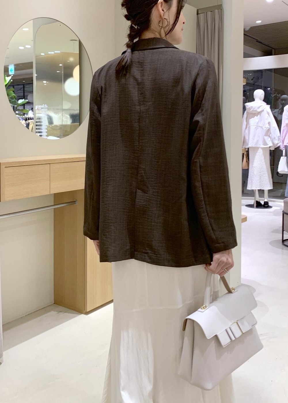 ホワイト系のハンドバッグ、ホワイト系のスカート、ホワイト系のニット/セーターを着用したレディースの春コーディネートの10枚目の写真