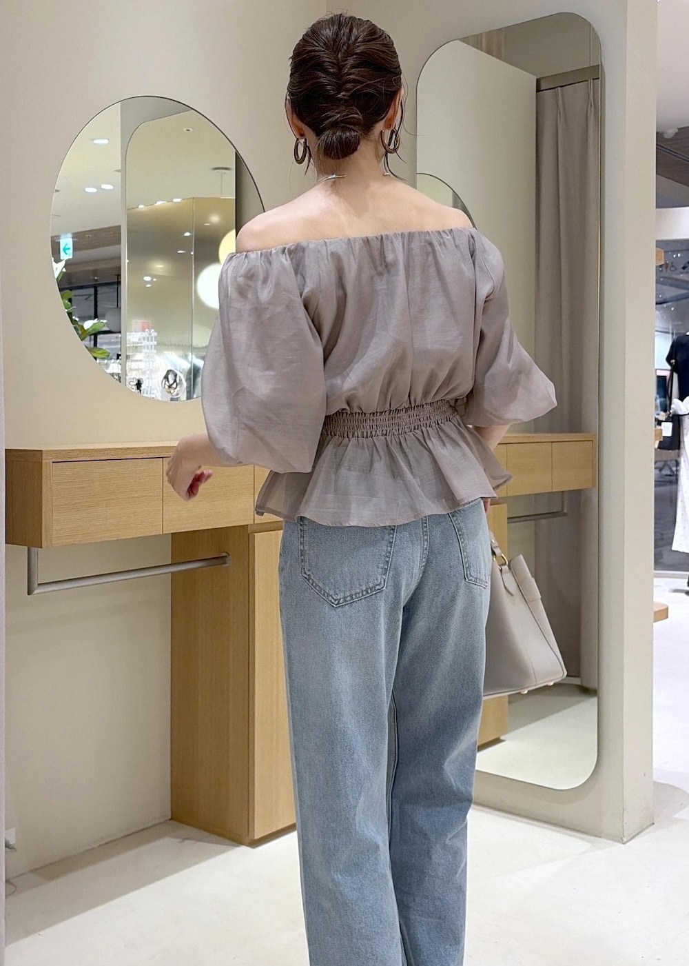 ホワイト系のパンプス、ベージュ系のシャツ/ブラウス、ブルー系のデニムパンツを着用したレディースの夏コーディネートの9枚目の写真