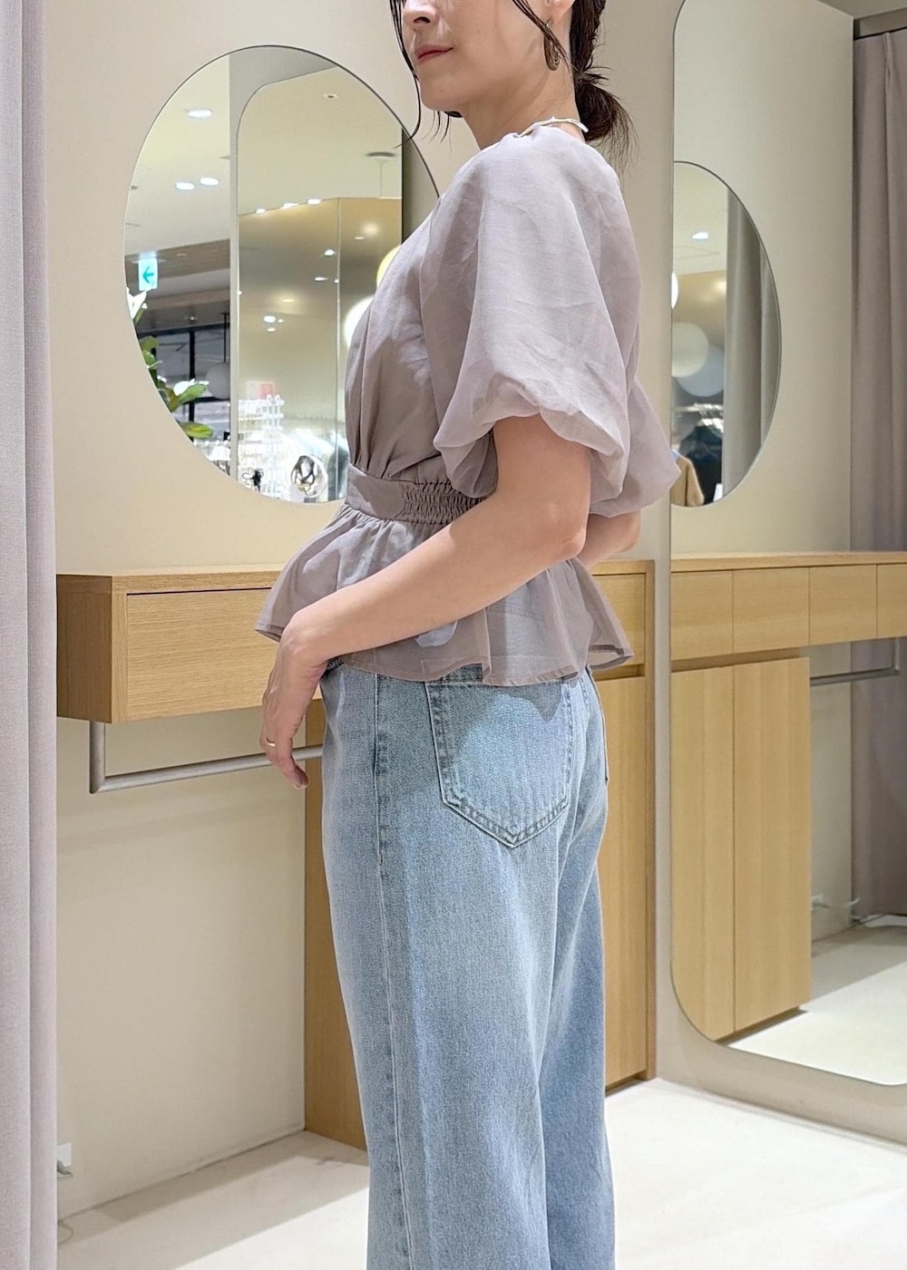 ホワイト系のパンプス、ベージュ系のシャツ/ブラウス、ブルー系のデニムパンツを着用したレディースの夏コーディネートの8枚目の写真