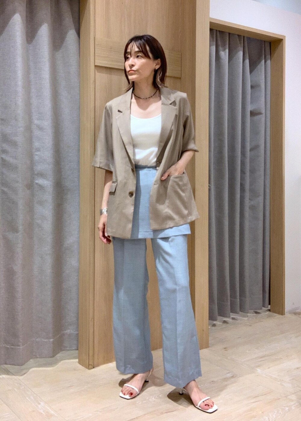 ホワイト系のキャミソール、ホワイト系のサンダル、ブルー系のスラックスを着用したレディースの夏コーディネートの3枚目の写真