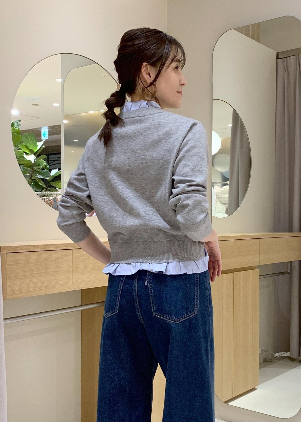 ブルー系のデニムパンツ、グレー系のその他アウター、ブラック系のショルダーバッグを着用したレディースの冬コーディネートの6枚目の写真