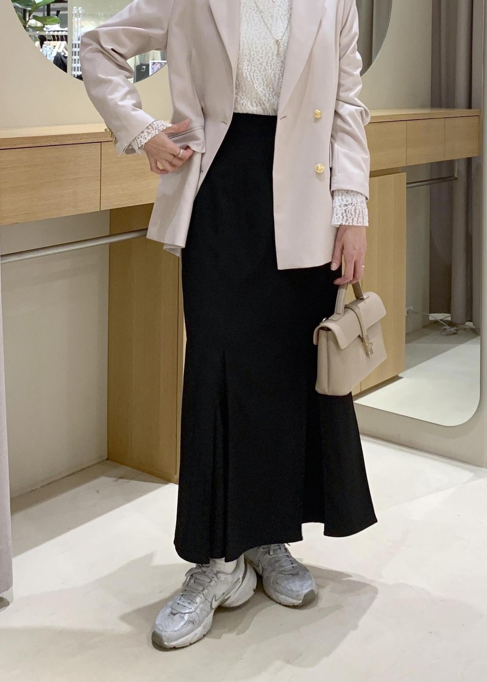 ブラック系のスカート、ホワイト系のTシャツ/カットソー、ベージュ系のテーラードジャケットを着用したレディースの冬コーディネートの9枚目の写真