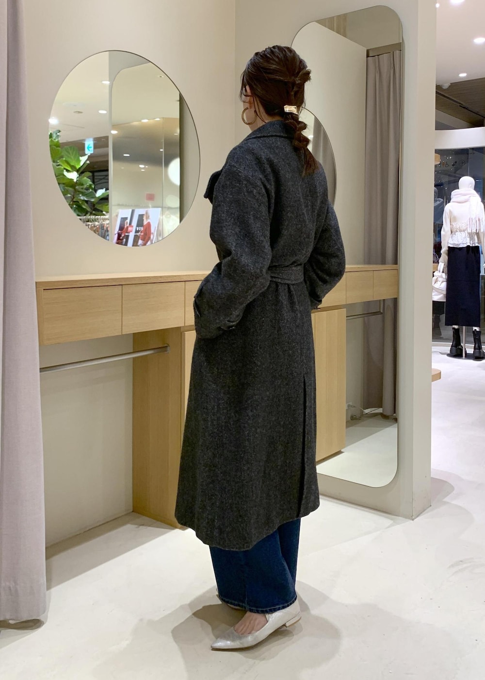 ブルー系のデニムパンツ、グレー系のその他アウター、ブラック系のショルダーバッグを着用したレディースの冬コーディネートの10枚目の写真