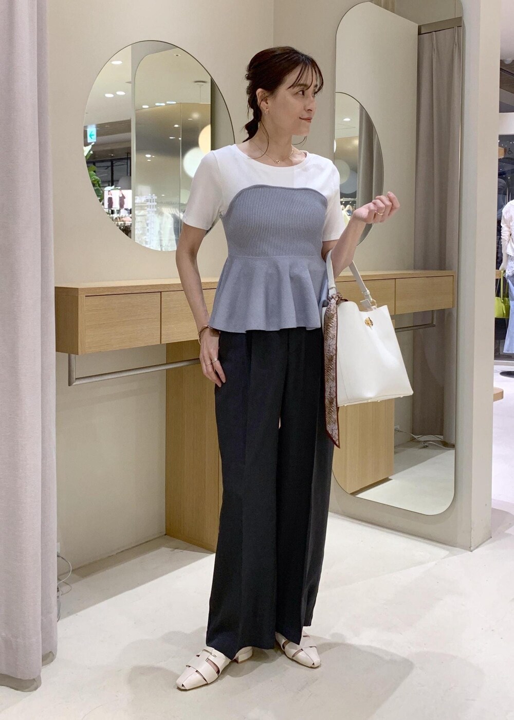 ホワイト系のショルダーバッグ、グレー系のその他パンツ、ホワイト系のパンプスを着用したレディースの春コーディネートの2枚目の写真