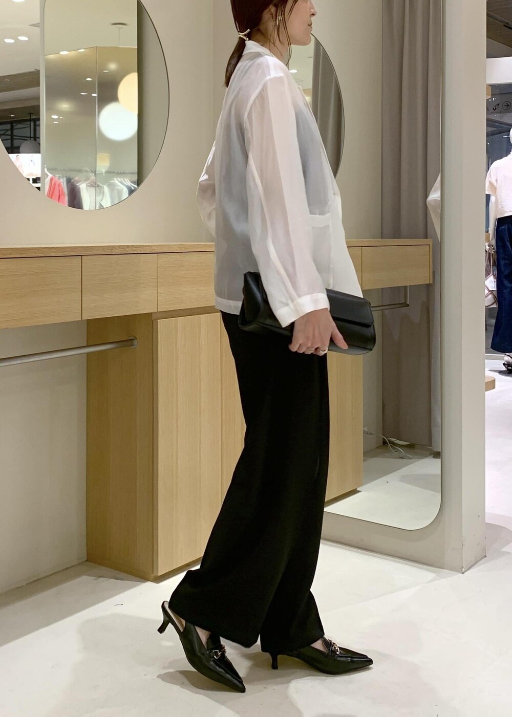 ブラック系のキャミソール、ブラック系のショルダーバッグ、ブラック系のパンプスを着用したレディースの春コーディネートの4枚目の写真