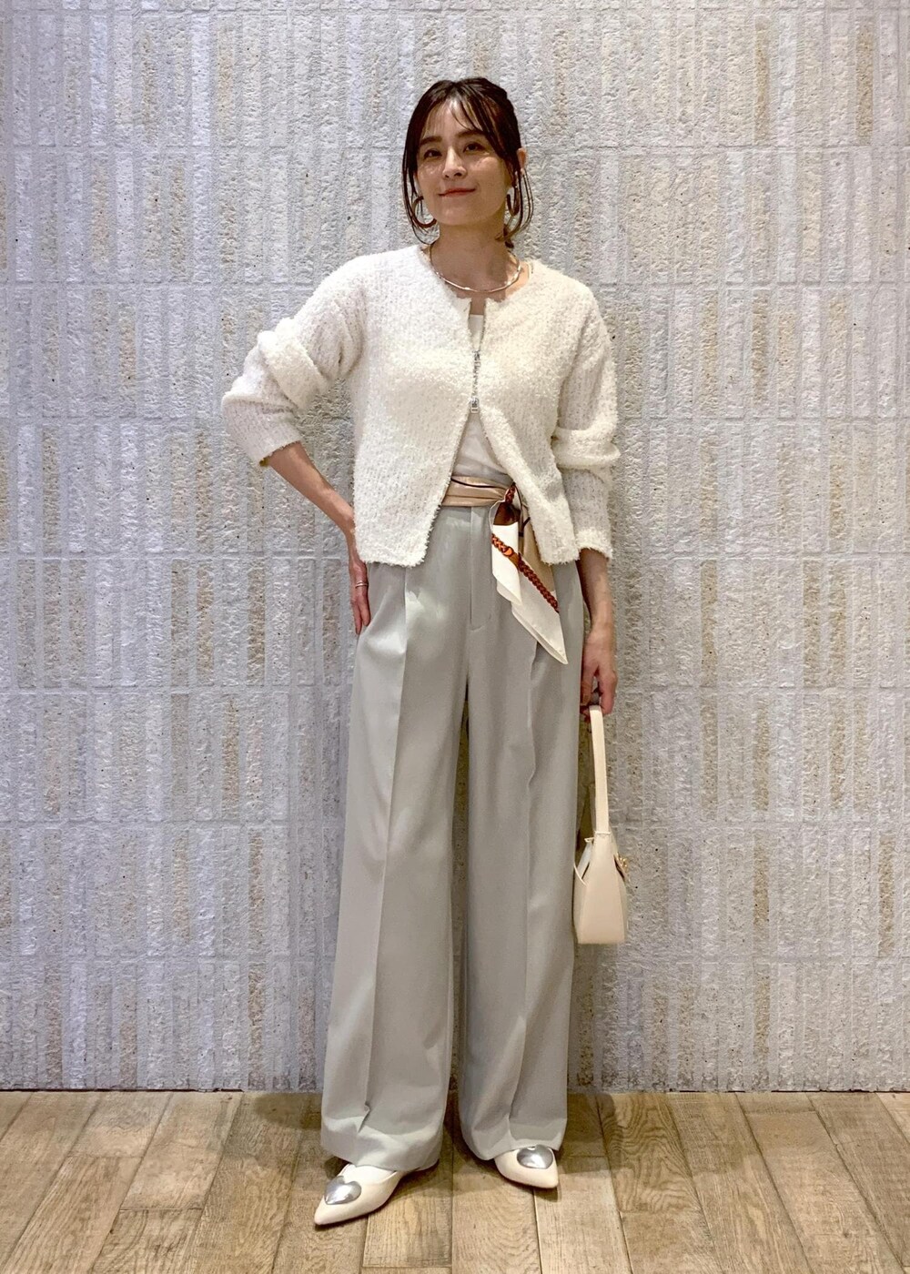 ホワイト系のハンドバッグ、ホワイト系のバレエシューズ、ホワイト系のキャミソールを着用したレディースの冬コーディネートの8枚目の写真