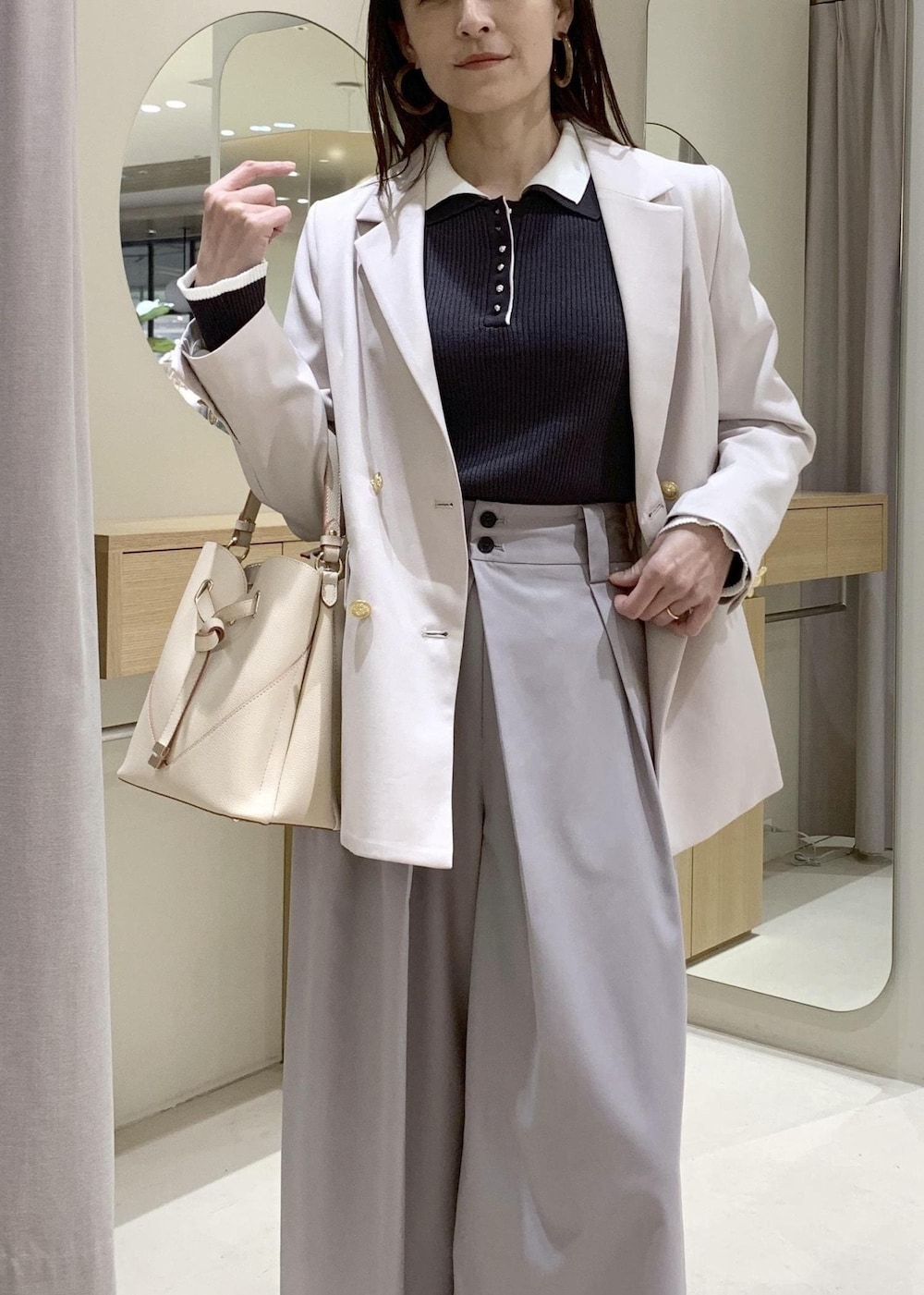 ベージュ系のショルダーバッグ、ブラック系のパンプス、ベージュ系のテーラードジャケットを着用したレディースの春コーディネートの5枚目の写真