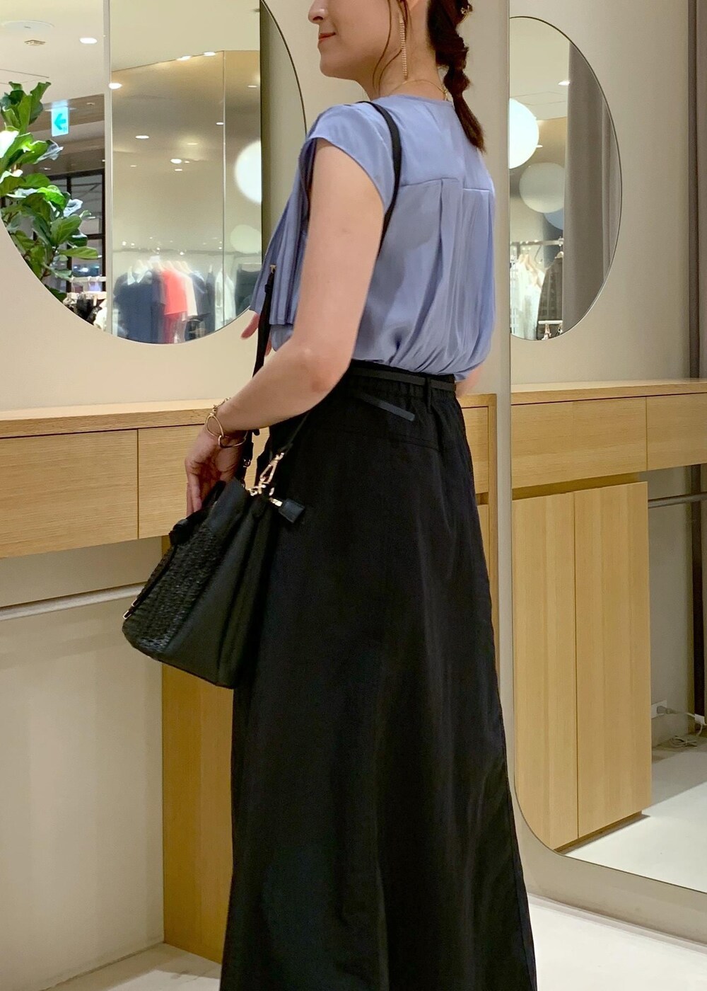 ブラック系のショルダーバッグ、ブルー系のシャツ/ブラウス、ブラック系のスカートを着用したレディースの夏コーディネートの6枚目の写真
