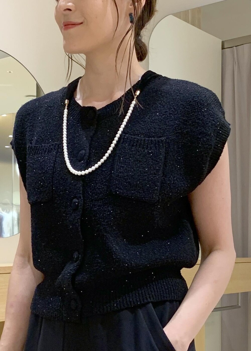 ブラック系のショルダーバッグ、ブラック系のカーディガン/ボレロ、ブラック系のキャミソールを着用したレディースの夏コーディネートの6枚目の写真