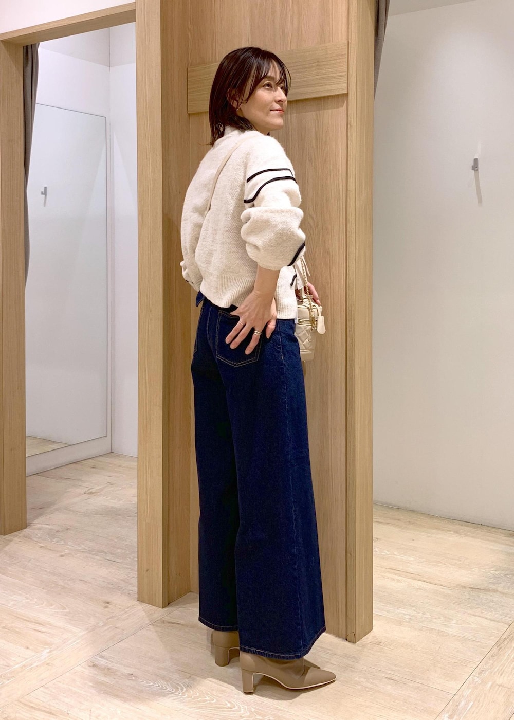 ブルー系のデニムパンツ、ベージュ系のブーツ、ホワイト系のシャツ/ブラウスを着用したレディースの冬コーディネートの7枚目の写真