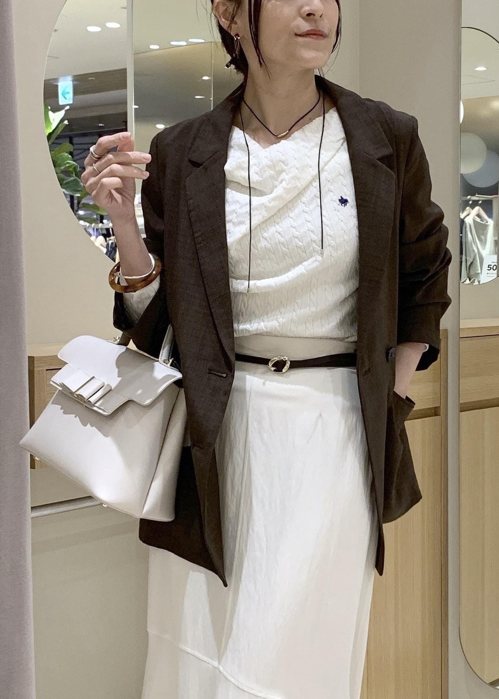 ホワイト系のハンドバッグ、ホワイト系のスカート、ホワイト系のニット/セーターを着用したレディースの春コーディネートの8枚目の写真