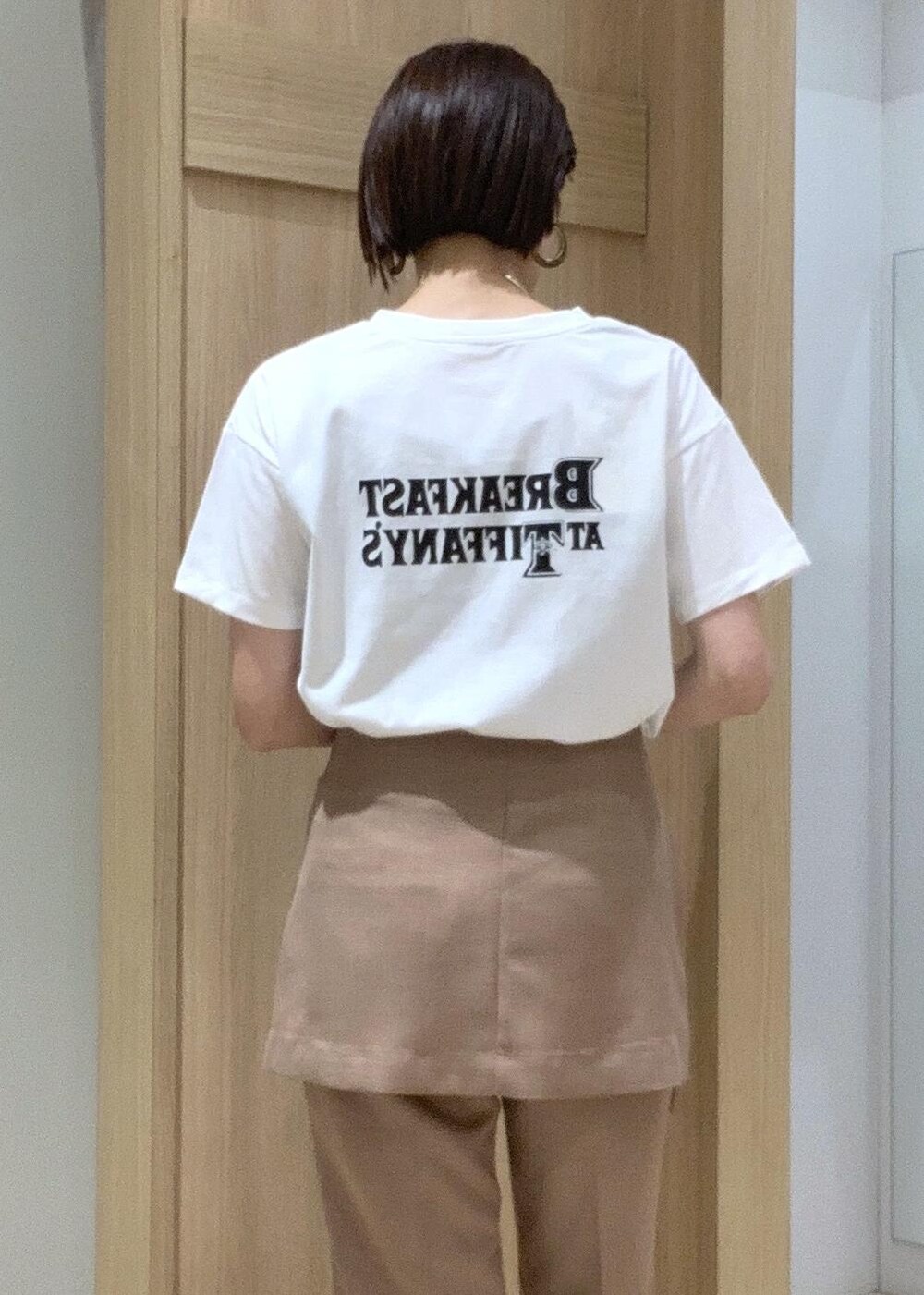 ホワイト系のTシャツ/カットソー、その他のサンダル、ブラウン系のスラックスを着用したレディースの夏コーディネートの8枚目の写真