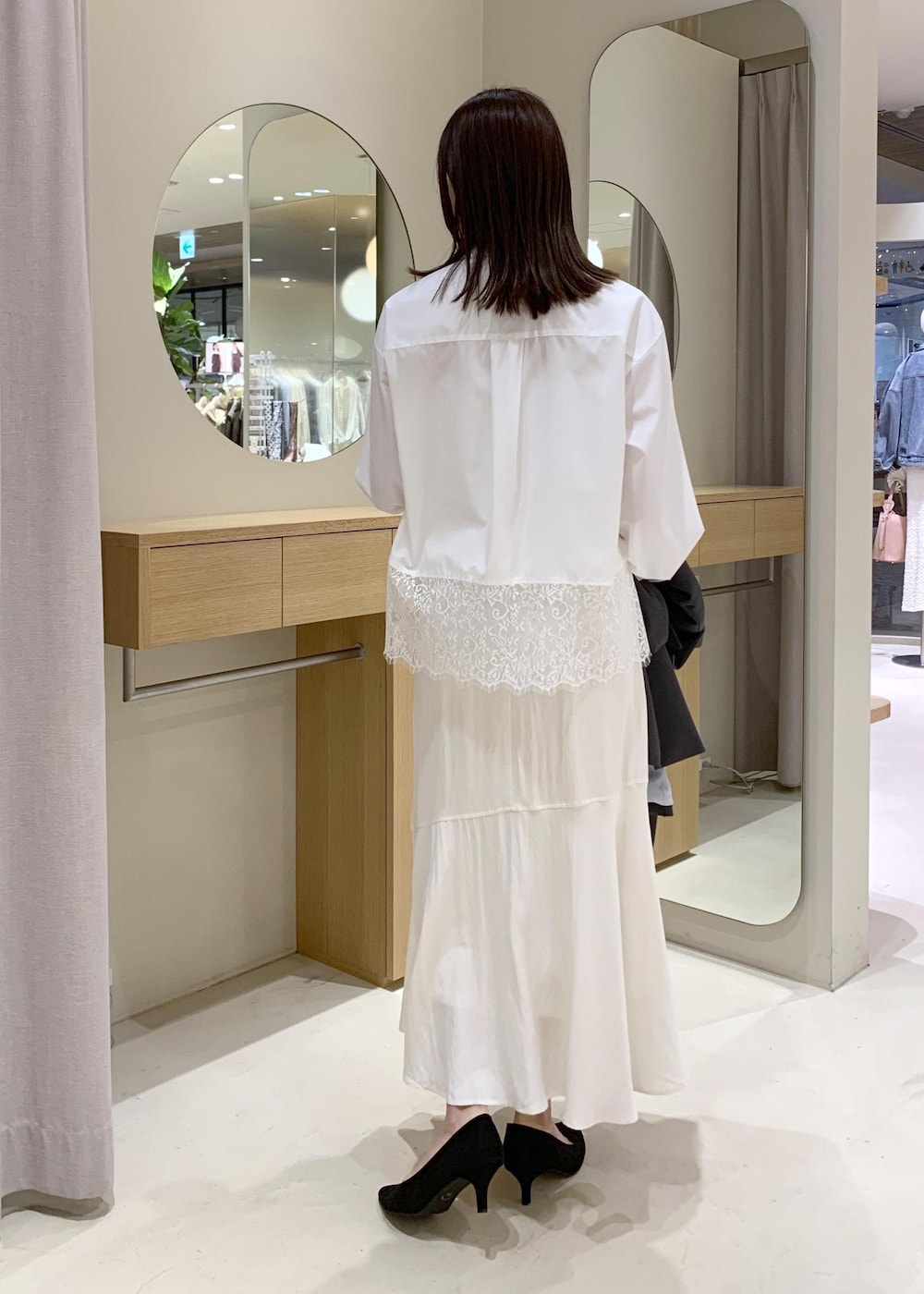 ブラック系のショルダーバッグ、ホワイト系のシャツ/ブラウス、ホワイト系のスカートを着用したレディースの春コーディネートの9枚目の写真