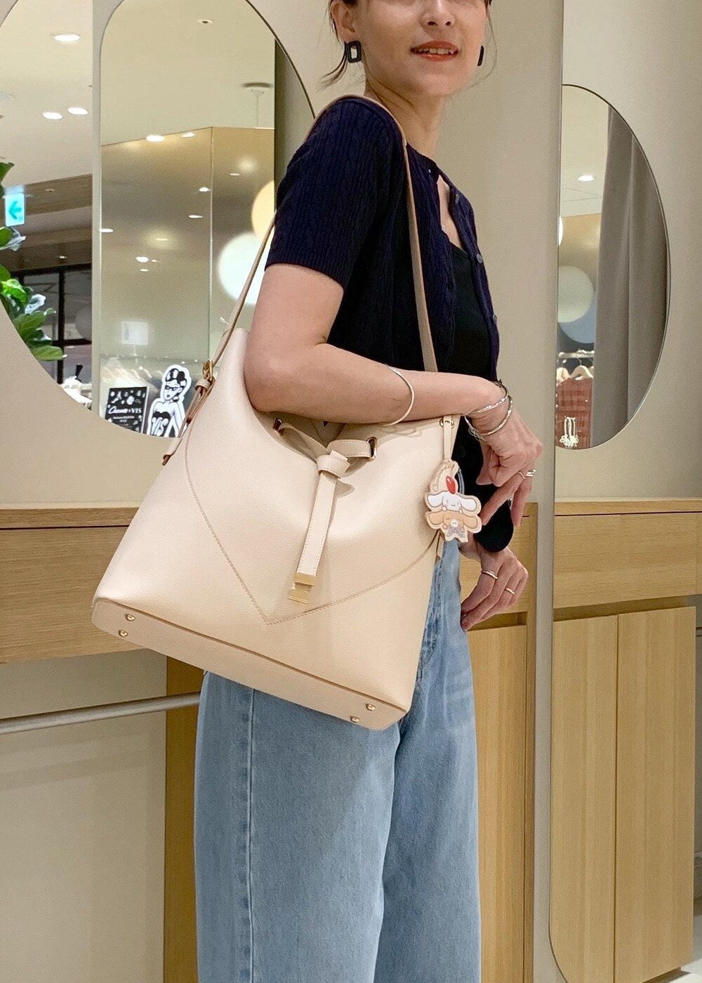 ブラック系のキャミソール、ブルー系のデニムパンツ、ホワイト系のサンダルを着用したレディースの夏コーディネートの3枚目の写真