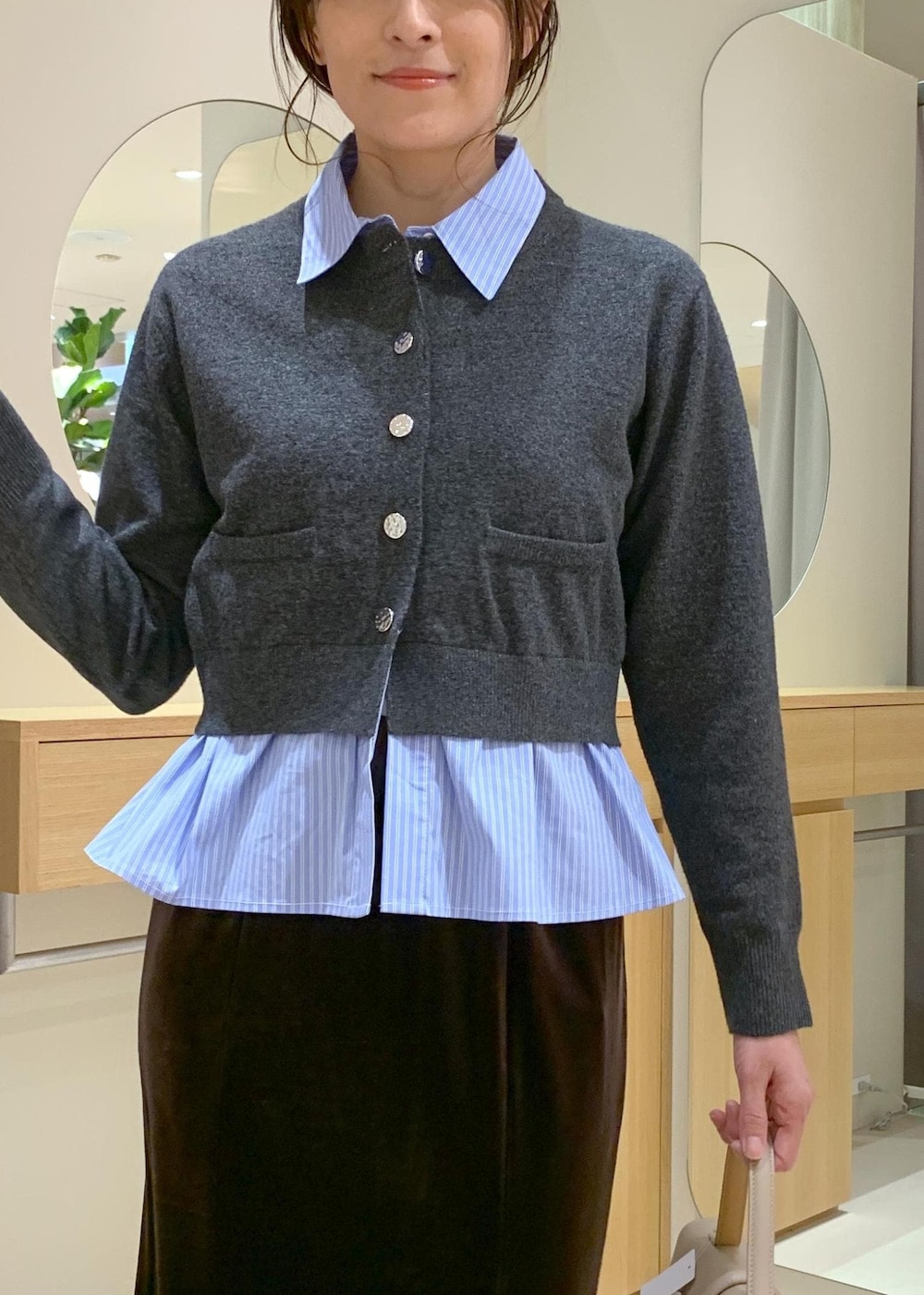 ベージュ系のハンドバッグ、ブラウン系のブーツ、ブラウン系のスカートを着用したレディースの秋コーディネートの5枚目の写真