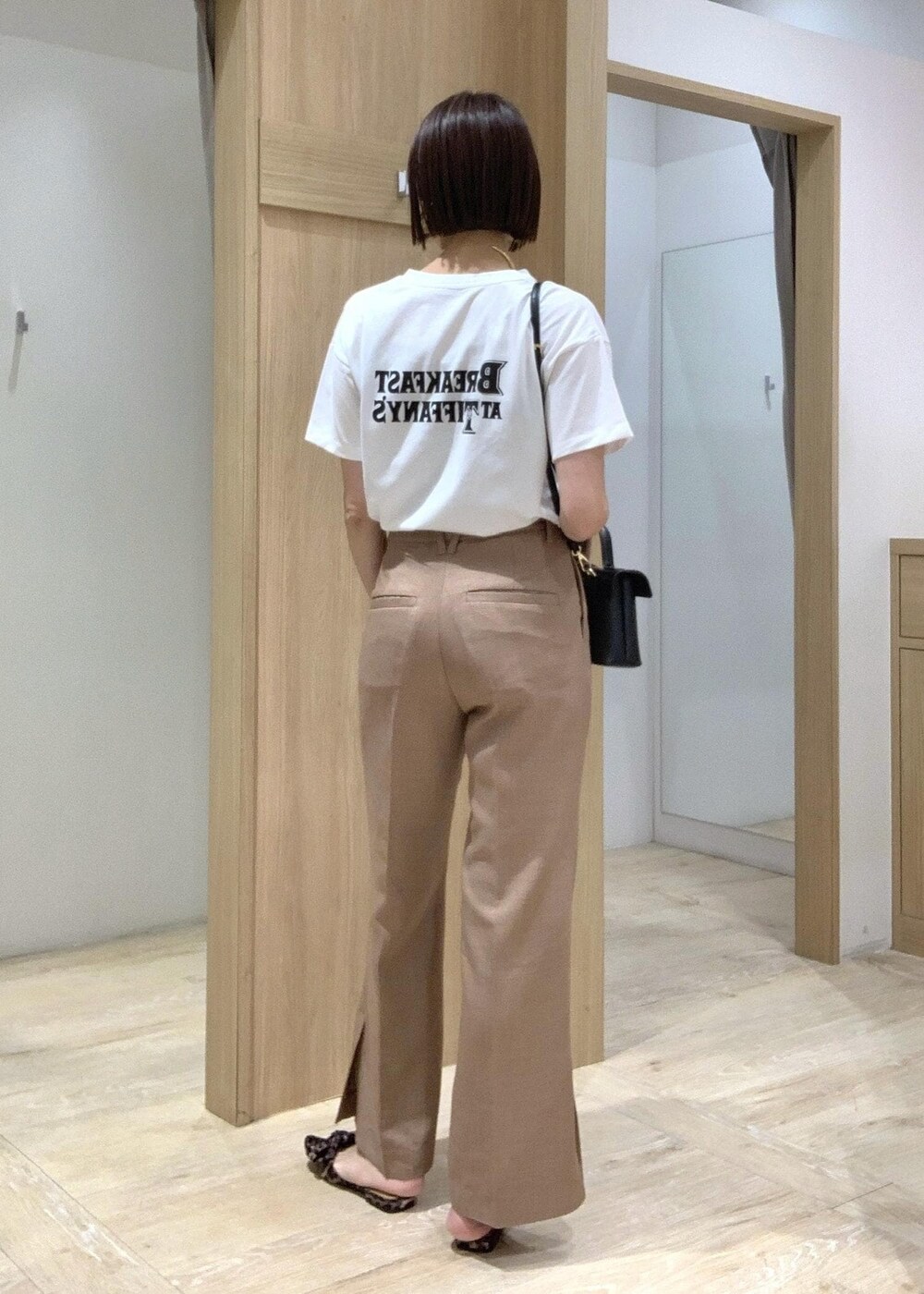 ホワイト系のTシャツ/カットソー、その他のサンダル、ブラウン系のスラックスを着用したレディースの夏コーディネートの6枚目の写真