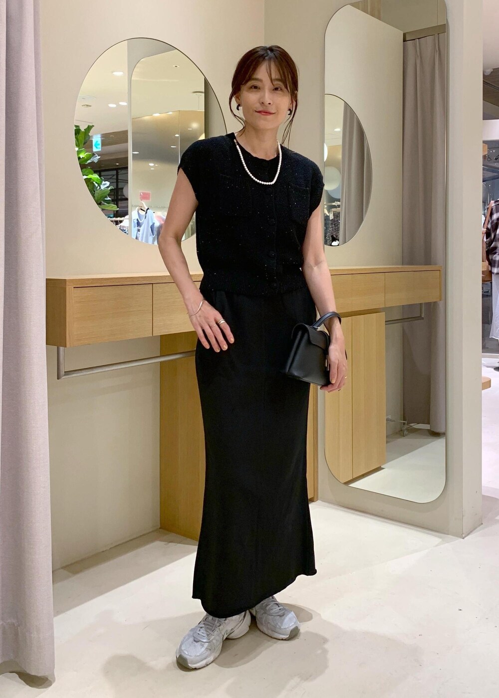 ブラック系のショルダーバッグ、ブラック系のカーディガン/ボレロ、ブラック系のキャミソールを着用したレディースの夏コーディネートの2枚目の写真