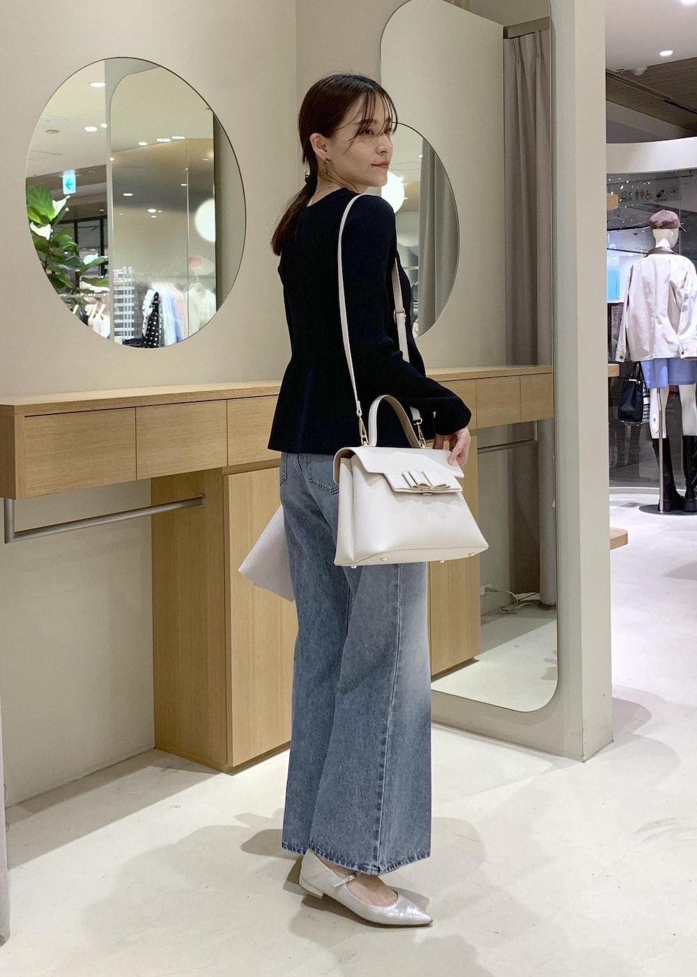 ブルー系のカーディガン/ボレロ、ブルー系のデニムパンツ、ベージュ系のテーラードジャケットを着用したレディースの冬コーディネートの2枚目の写真