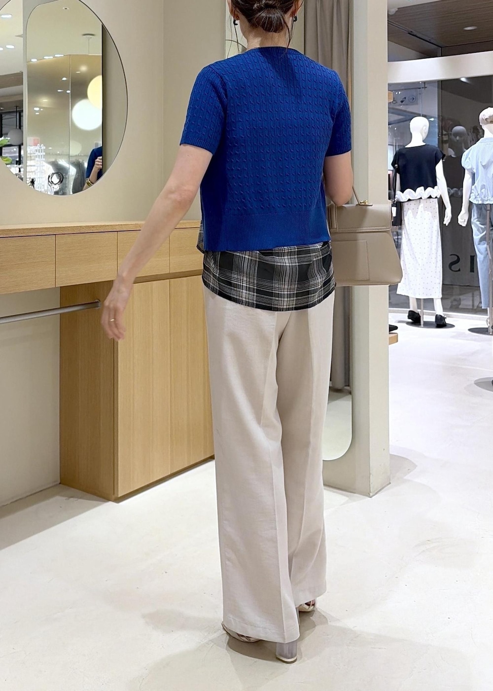 ベージュ系のハンドバッグ、ホワイト系のその他パンツ、ブラック系のシャツ/ブラウスを着用したレディースの夏コーディネートの3枚目の写真