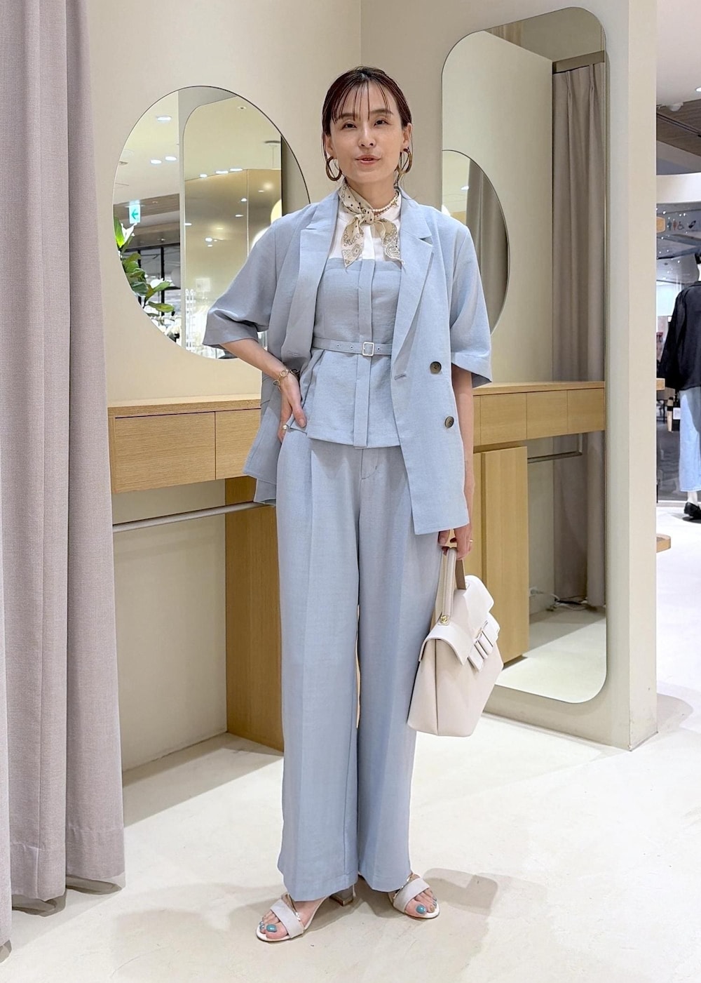 ホワイト系のハンドバッグ、ホワイト系のサンダル、ブルー系のその他パンツを着用したレディースの春コーディネートの2枚目の写真