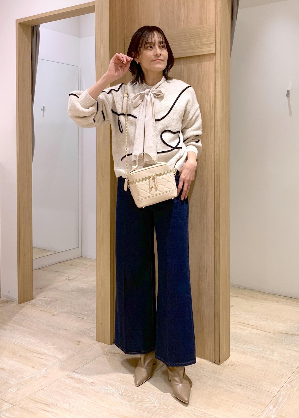 ブルー系のデニムパンツ、ベージュ系のブーツ、ホワイト系のシャツ/ブラウスを着用したレディースの冬コーディネートの5枚目の写真