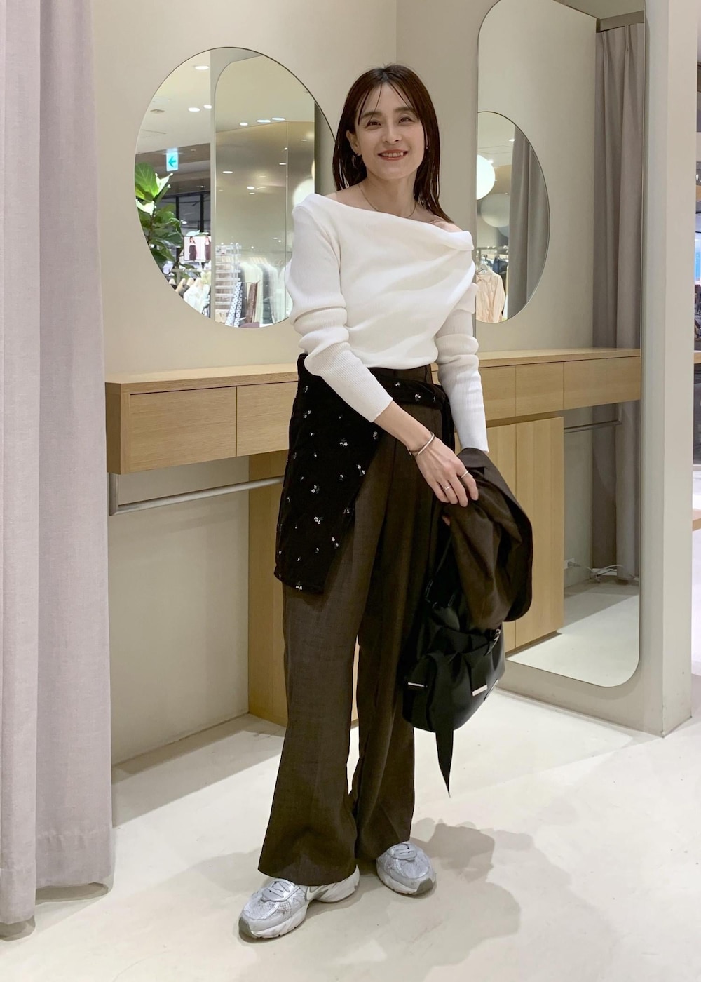 ブラック系のトートバッグ、ブラウン系のカーディガン/ボレロ、ホワイト系のニット/セーターを着用したレディースの春コーディネートの5枚目の写真
