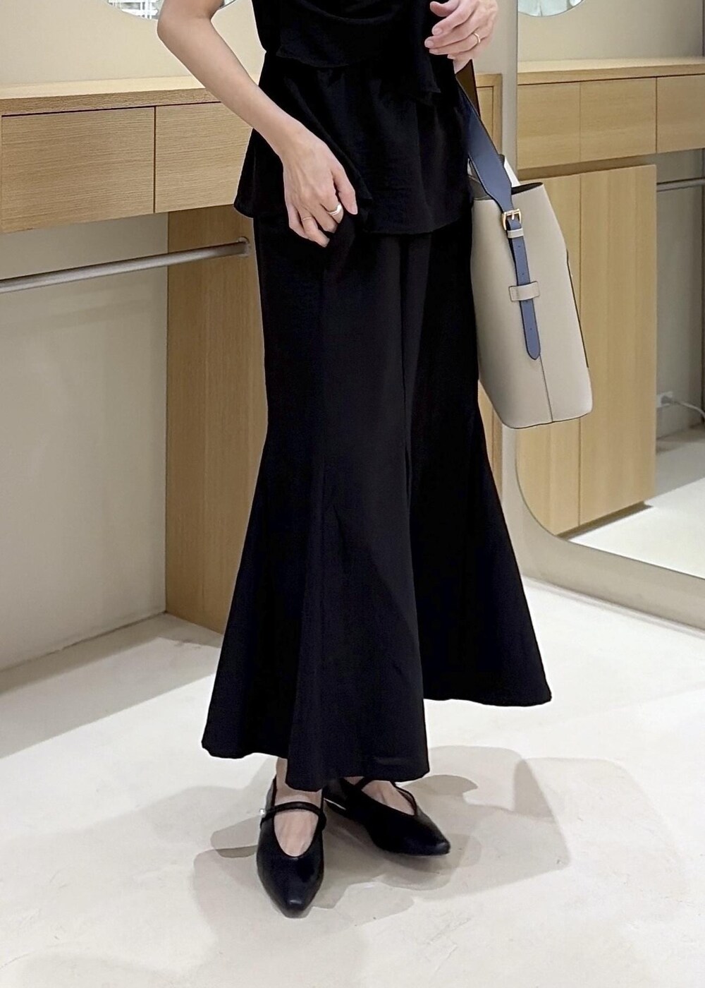 ベージュ系のトートバッグ、ブラック系のパンプス、ブラック系のTシャツ/カットソーを着用したレディースの春コーディネートの9枚目の写真