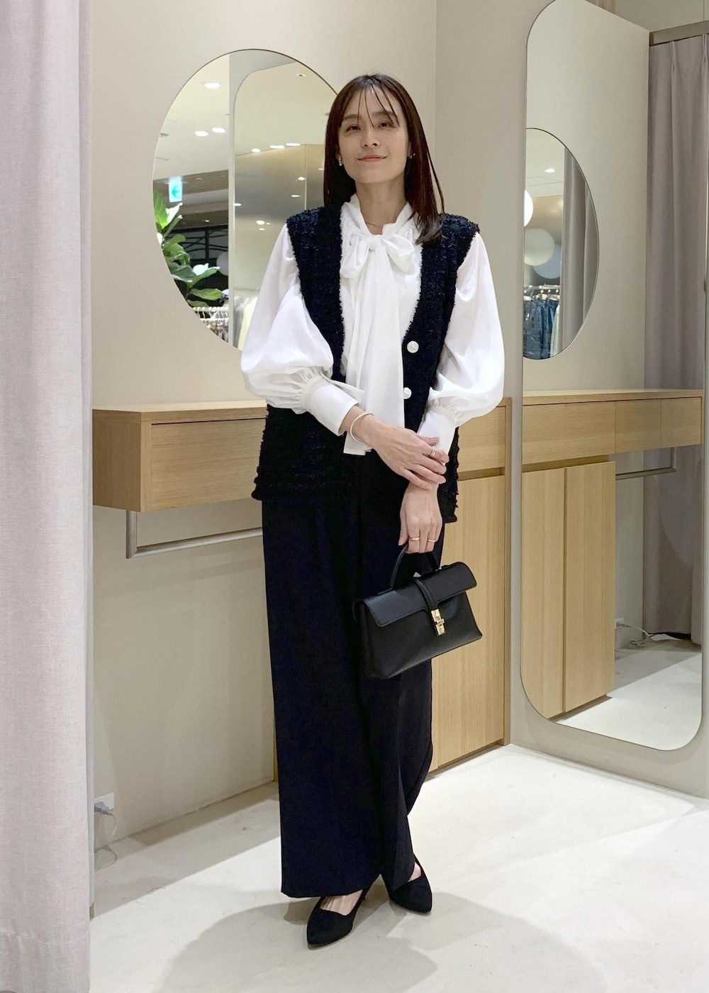 ブラック系のショルダーバッグ、ブルー系のその他パンツ、ホワイト系のシャツ/ブラウスを着用したレディースの冬コーディネートの2枚目の写真