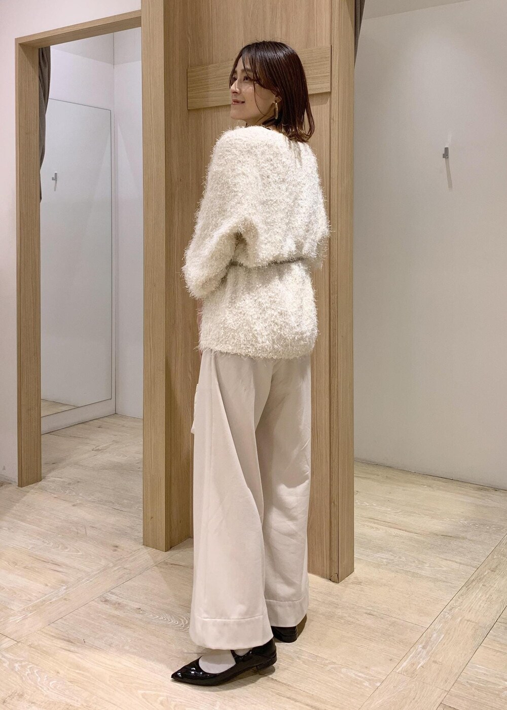 ブラック系のキャミソール、ホワイト系のカーディガン/ボレロ、ベージュ系のその他パンツを着用したレディースの冬コーディネートの7枚目の写真