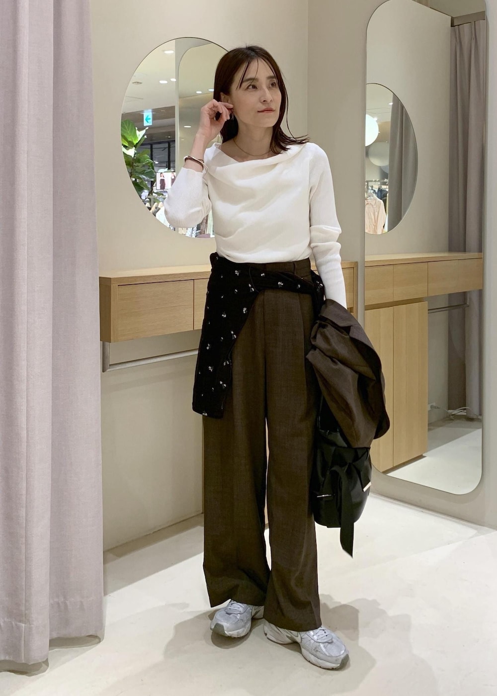 ブラック系のトートバッグ、ブラウン系のカーディガン/ボレロ、ホワイト系のニット/セーターを着用したレディースの春コーディネートの6枚目の写真