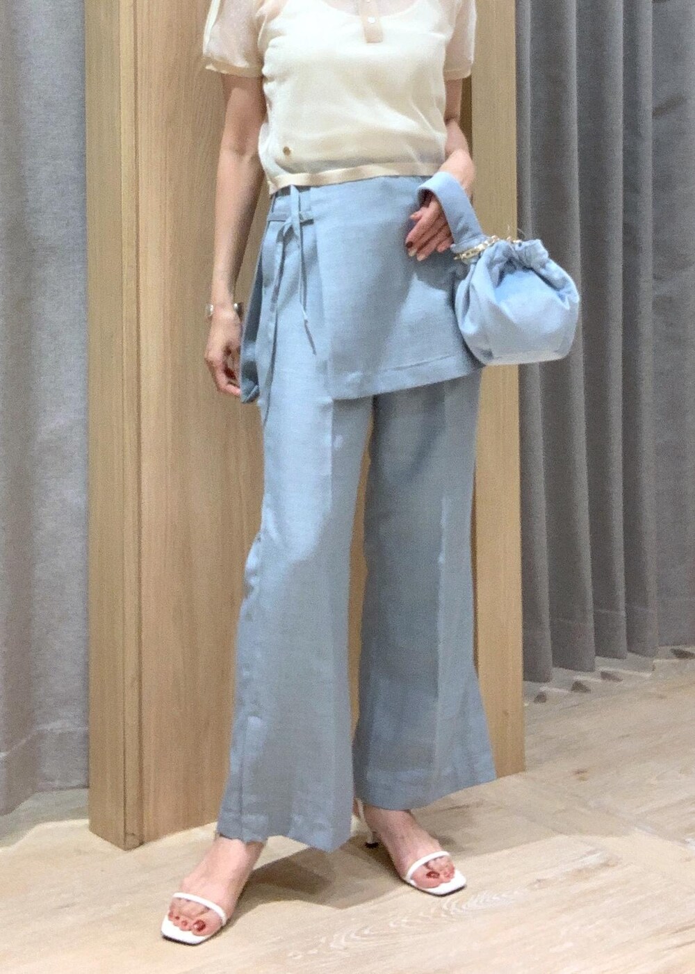ホワイト系のサンダル、ブルー系のスラックス、ブルー系のハンドバッグを着用したレディースの夏コーディネートの8枚目の写真