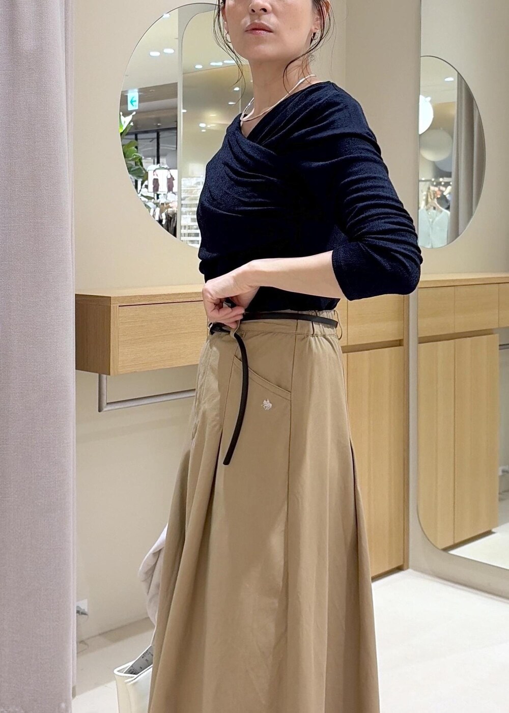 ホワイト系のテーラードジャケット、ベージュ系のスカート、ブルー系のTシャツ/カットソーを着用したレディースの春コーディネートの10枚目の写真