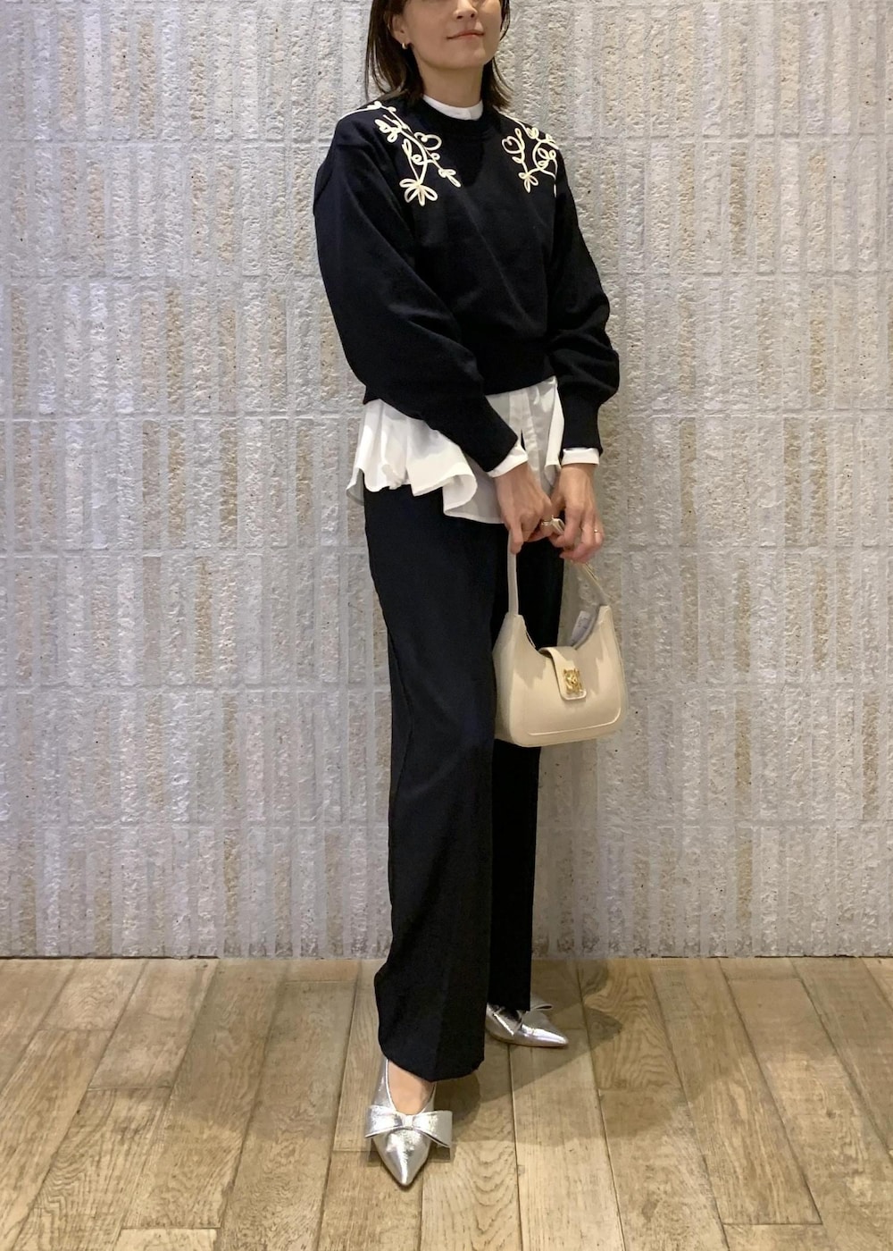 シルバー系のパンプス、ホワイト系のシャツ/ブラウス、ホワイト系のハンドバッグを着用したレディースの冬コーディネートの2枚目の写真