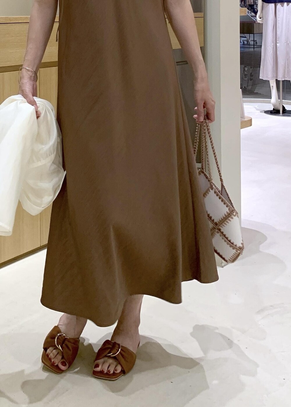 イエロー系のサンダル、ブラウン系のワンピース、ブラック系のタンクトップを着用したレディースの夏コーディネートの9枚目の写真