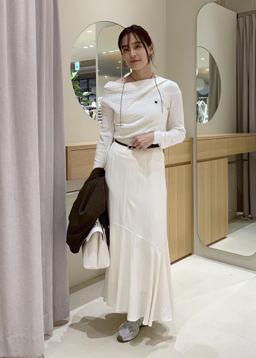 ホワイト系のハンドバッグ、ホワイト系のスカート、ホワイト系のニット/セーターを着用したレディースの春コーディネートの5枚目の写真