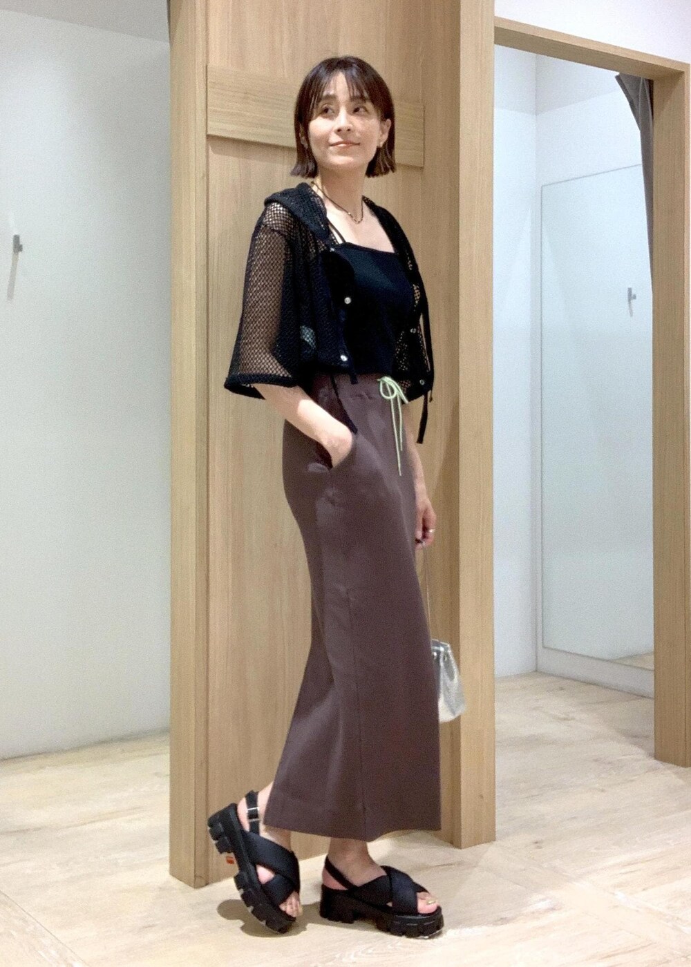 ブラック系のキャミソール、ブラック系のサンダル、シルバー系のショルダーバッグを着用したレディースの夏コーディネートの2枚目の写真