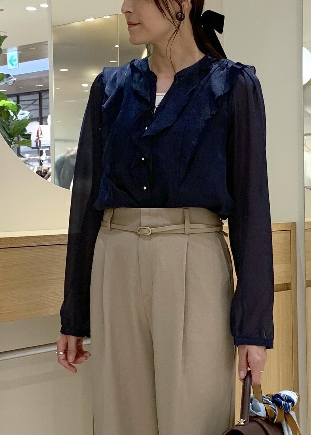 ブラウン系のハンドバッグ、ホワイト系のパンプス、ブルー系のシャツ/ブラウスを着用したレディースの秋コーディネートの5枚目の写真