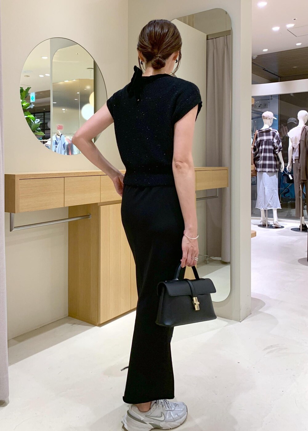 ブラック系のショルダーバッグ、ブラック系のカーディガン/ボレロ、ブラック系のキャミソールを着用したレディースの夏コーディネートの3枚目の写真