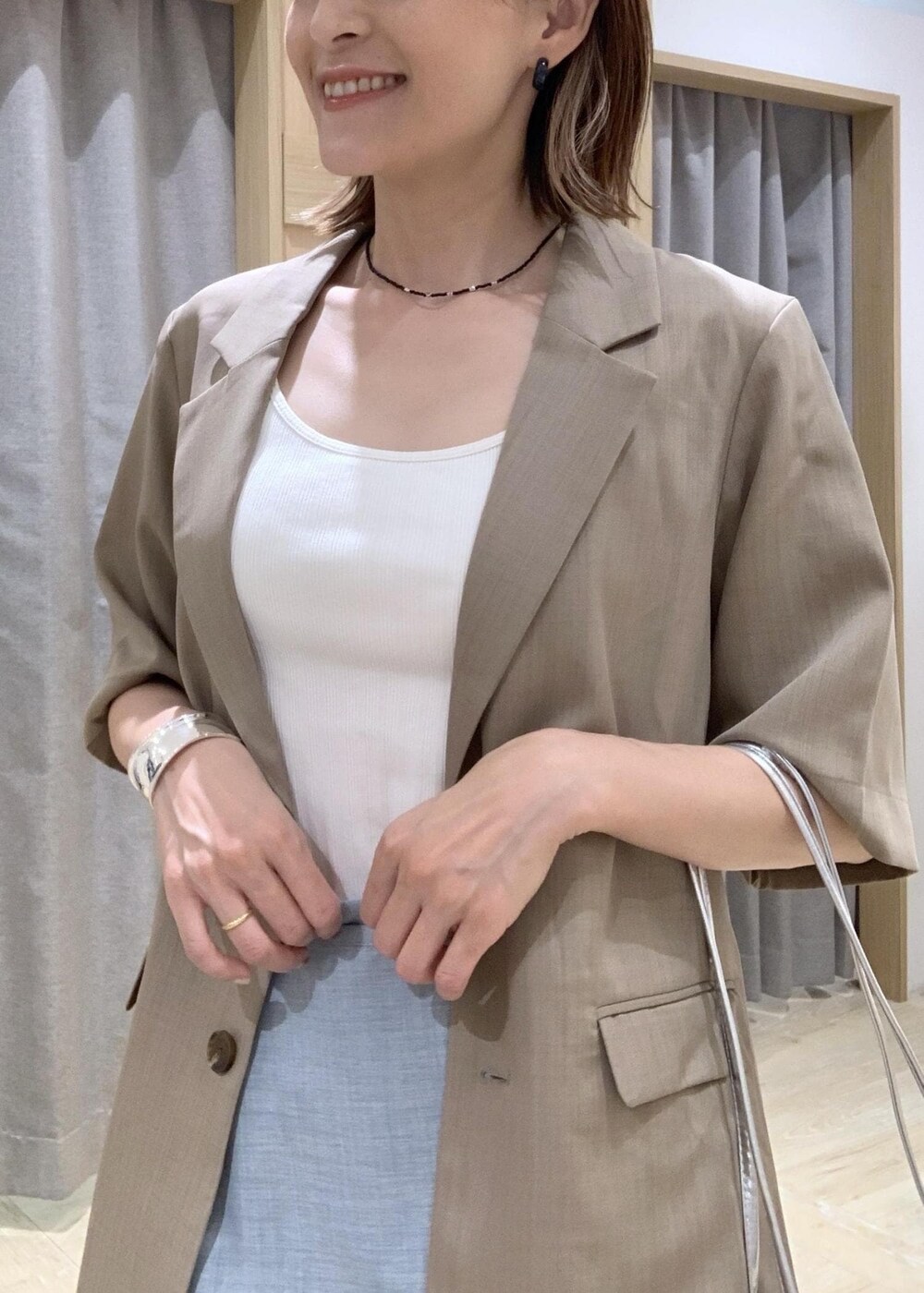 ホワイト系のキャミソール、ホワイト系のサンダル、ブルー系のスラックスを着用したレディースの夏コーディネートの6枚目の写真