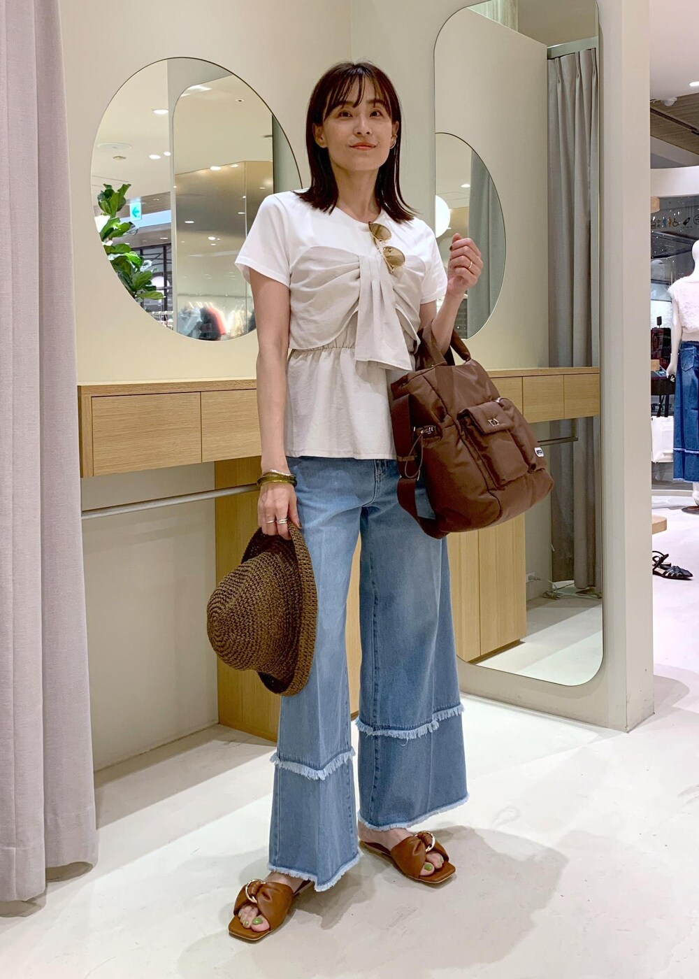 イエロー系のサンダル、ホワイト系のTシャツ/カットソー、ブルー系のデニムパンツを着用したレディースの夏コーディネートの2枚目の写真