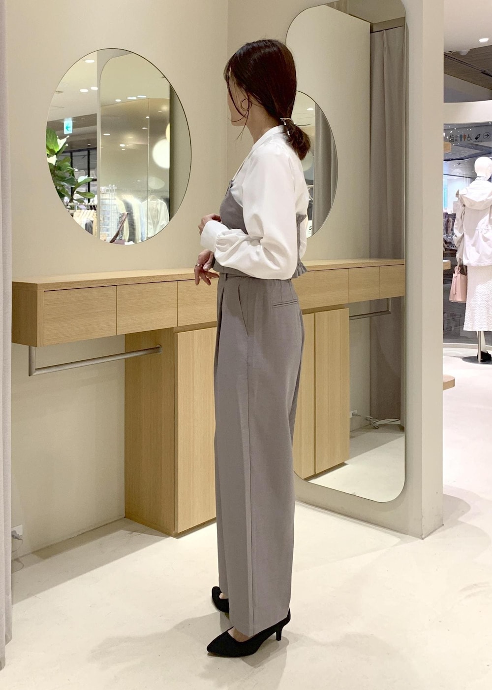 ベージュ系のショルダーバッグ、ブラック系のブルゾン、グレー系のシャツ/ブラウスを着用したレディースの春コーディネートの6枚目の写真