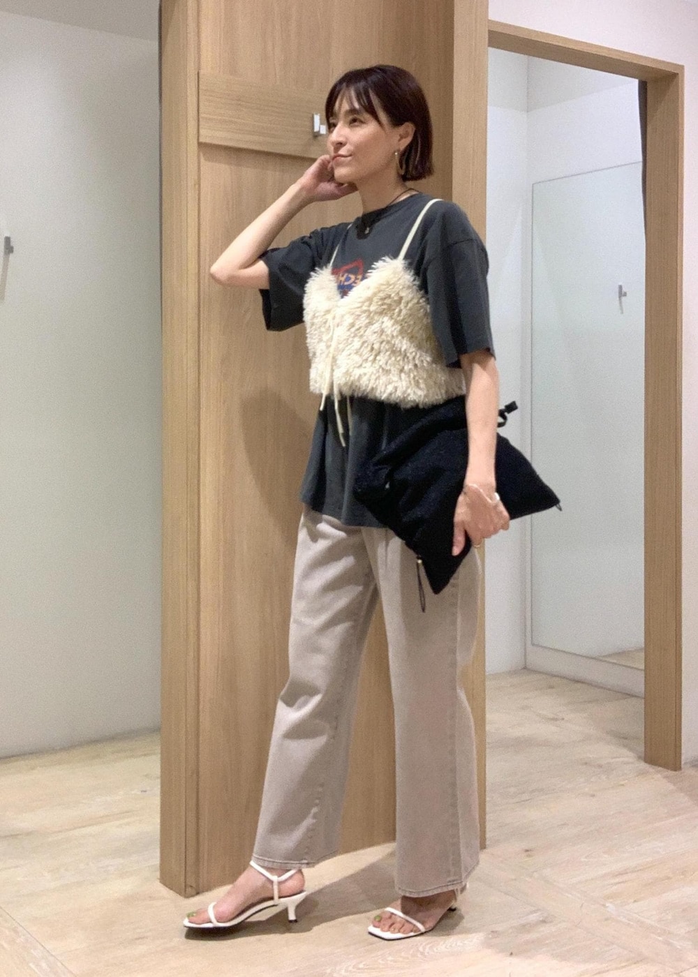 ホワイト系のサンダル、ブラック系のショルダーバッグ、ホワイト系のキャミソールを着用したレディースの夏コーディネートの3枚目の写真